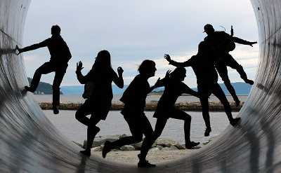 People dancing in a large cement pipe