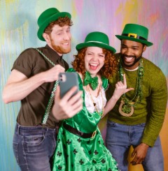 A girl and two guys smiling and dressed up for St Patrick's Day