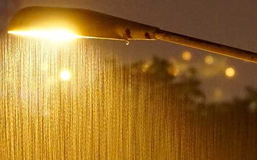 Image of rain coming down with a streetlight in the background