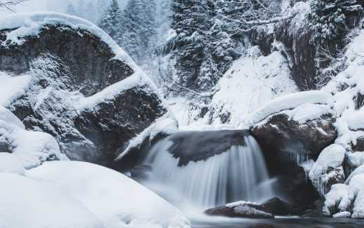 Image of a small waterfall surrounded by snow